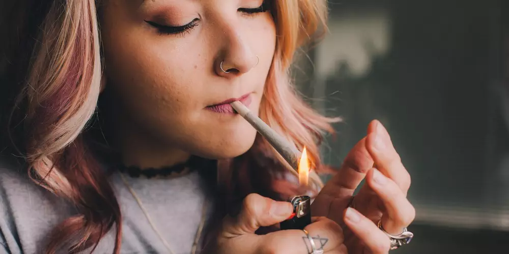 girl smoking a joint with a lighter