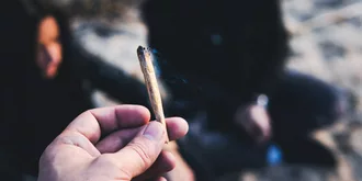 lit joint being held up in front of people